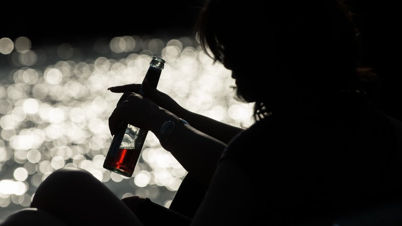  Eine junge Frau sitzt mit einem Biermixgetränk an der Spree. © Florian Gaertner/dpa 