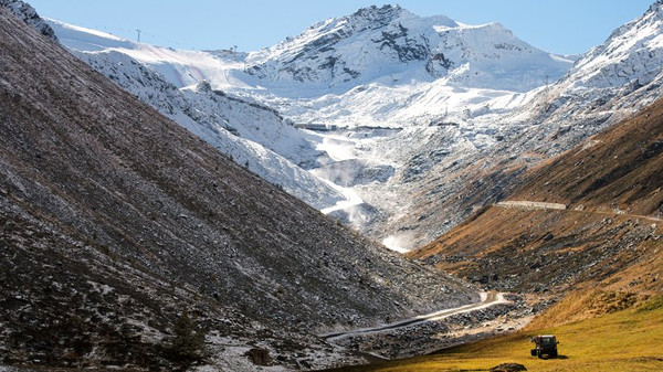 Die Welt ist schon fremd genug, bitte nicht noch mehr davon. Ein Landwirt bei der Arbeit, im Hintergrund der Rettenbach-Gletscher in Österreich © Christian Bruna/dpa