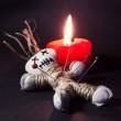 Voodoo-Puppe vor Kerze