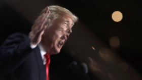  US-Präsident Donald Trump, gespiegelt in einem Glas © Evan Vucci/AP/dpa 
